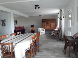 a dining room with a large white table and chairs at Gîte breton au bord du GR34 in Landunvez