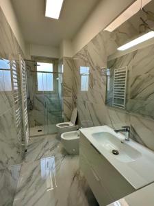 La salle de bains est pourvue d'un lavabo, de toilettes et d'un miroir. dans l'établissement Bicocca Modern Apartment, à Milan