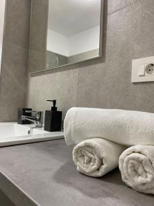 La salle de bains est pourvue d'un lavabo et de serviettes sur un comptoir. dans l'établissement Comfort & Luxury Apartaments PNMresidence, à Timişoara