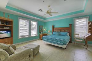 una camera da letto con pareti blu, un letto e un divano di Celebration House Villa a Captiva Altre 19 foto