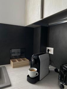 een kopje koffie naast een koffiezetapparaat bij Comfort & Luxury Apartaments PNMresidence in Timişoara