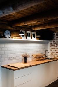 a kitchen with a counter with a clock on the wall at ŽOLIŲ NAMELIS in Antalkiai