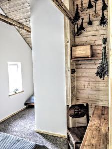 a bedroom with a wooden wall and a wooden chair at ŽOLIŲ NAMELIS in Antalkiai