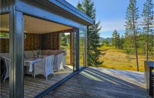 a wooden house with a table and chairs on a deck at Awesome Home In Hjartdal With Kitchen in Hjartdal