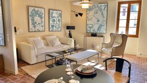 een woonkamer met een bank en een tafel en stoelen bij La Dolce Vita in Beaune
