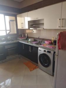 cocina con lavadora y fregadero en Maison de fatima, en Azrou