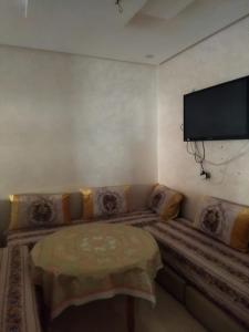 sala de estar con sofá y TV de pantalla plana en Maison de fatima, en Azrou