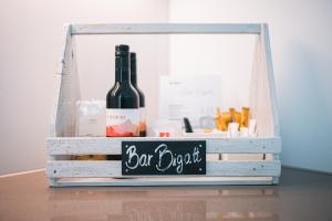 una botella de vino y un cartel en una caja de madera en Bigatt Hotel & Restaurant, en Lugano