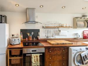 a kitchen with a counter top with a stove top oven at Brynhoreb in Llanilar