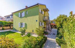 a yellow house with a garden in front of it at Amazing Apartment In Medulin With 3 Bedrooms And Wifi in Medulin