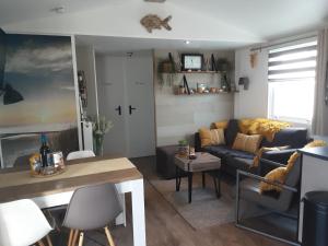 a living room with a couch and a table at Chalet Zeewind in Oostkapelle