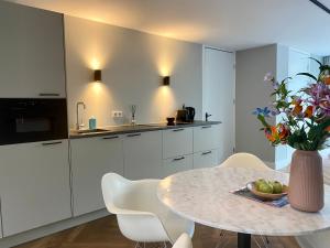 a kitchen with a table with a vase of flowers at Studio 157, in de stad aan de gracht in Kampen +7 photos