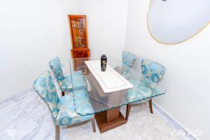 a dining room table with two chairs and a mirror at Clos d'Or, Appartements meublés Douala Makepé in Douala