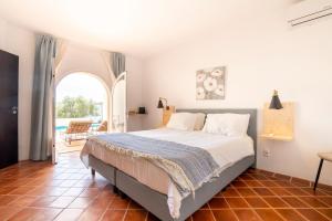 a bedroom with a bed and an arched window at B&B Casa do Cerro in Moncarapacho