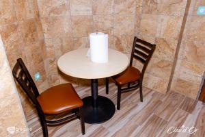 a table with two chairs and a candle on it at Clos d'Or, Appartements meublés Douala Makepé in Douala