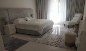 - une chambre avec un lit, une chaise et une fenêtre dans l'établissement Balqis Residense Palm Jumeirah,Pool, Beach, Top floor, Full sea view, Restaurants, à Dubaï