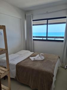 um quarto com uma cama com um cisne em Apartamento frente mar praia do flamengo em Salvador
