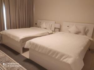 - 2 lits dans une chambre d'hôtel avec des draps blancs dans l'établissement Balqis Residense Palm Jumeirah,Pool, Beach, Top floor, Full sea view, Restaurants, à Dubaï