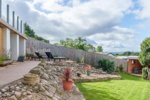 a backyard with a stone wall and a fence at Offa's Lodge Family home quiet area with sea views in Prestatyn