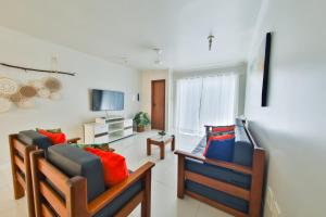 a living room with two chairs and a television at Apartamento Mont Sião II in Porto Seguro