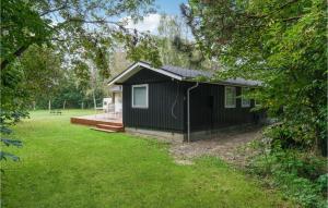 a black house with a deck in a yard at 3 Bedroom Lovely Home In Thyholm in Thyholm