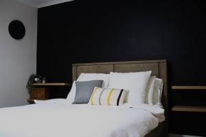 ein Schlafzimmer mit einem großen Bett mit weißer Bettwäsche und Kissen in der Unterkunft Gum Lodge, Gateway to the Murray in Loxton