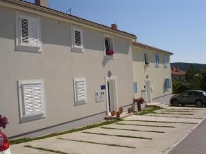 a house with a car parked in front of it at Apartments Matej & Irena in Cres