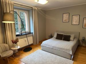 um quarto com uma cama, uma cadeira e uma janela em Dobra 19 em Katowice