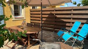 een tafel en stoelen en een parasol op een patio bij Villa les Pensées La Londe in La Londe-les-Maures