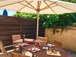 a wooden table with an umbrella on a patio at Villa les Pensées La Londe in La Londe-les-Maures