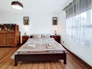 ein Schlafzimmer mit einem Bett und einem großen Fenster in der Unterkunft Gryglówka Noclegi in Zembrzyce