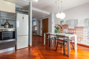 een keuken met een tafel en een witte koelkast bij Assago amazing flat in Assago