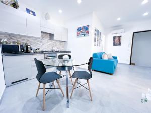 eine Küche und ein Wohnzimmer mit einem Glastisch und Stühlen in der Unterkunft Appartamento al centro storico in Caltagirone