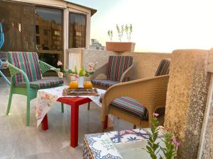 Un patio con sillas y una mesa en el balcón. en GEM & Pyramids Entire Apartment, en El Cairo