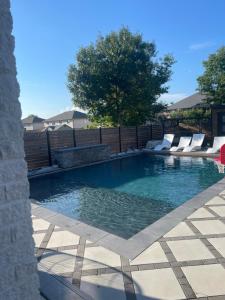 a swimming pool with lounge chairs in a backyard at Luxury Modern smart home for vacation in Windsor