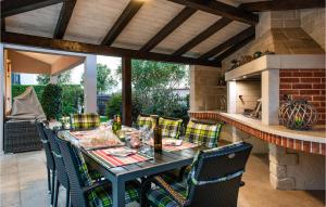 Une table à manger et des chaises sont disponibles sur la terrasse. dans l'établissement Beautiful Home In Loborika With Wi-fi, à Loborika