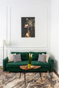 a living room with a green couch and a table at Luxurious Prestige Residence next to the New York Café in Budapest