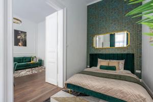 a bedroom with a bed and a mirror on a wall at Luxurious Prestige Residence next to the New York Café in Budapest