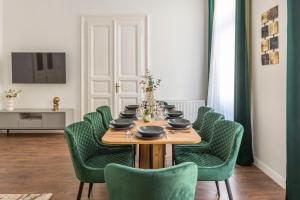a dining room with a table and green chairs at Luxurious Prestige Residence next to the New York Café in Budapest