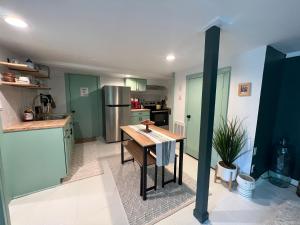 a kitchen with green cabinets and a wooden table at Sugar Sweet Home in Asheville