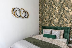 a bedroom with a bed with a green headboard at Luxurious Prestige Residence next to the New York Café in Budapest