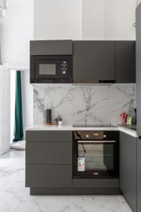a kitchen with a stove and a microwave at Luxurious Prestige Residence next to the New York Café in Budapest