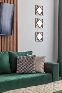 a green couch sitting in a living room at Luxurious Prestige Residence next to the New York Café in Budapest