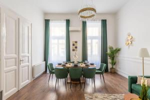 a dining room with a table and green chairs at Luxurious Prestige Residence next to the New York Café in Budapest