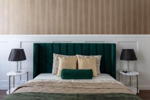 a bed with a green headboard and two lamps at Luxurious Prestige Residence next to the New York Café in Budapest