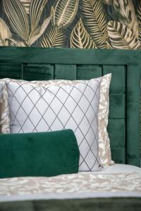 a green and white pillow sitting on a bed at Luxurious Prestige Residence next to the New York Café in Budapest