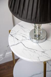 a white marble table with a lamp on it at Luxurious Prestige Residence next to the New York Café in Budapest