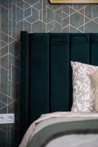 a bed with a green headboard and a pillow at Luxurious Prestige Residence next to the New York Café in Budapest