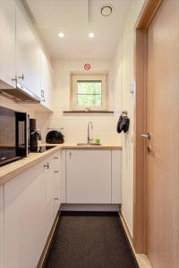 a kitchen with white cabinets and a sink at Casa Marit in Westouter