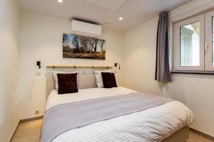 1 dormitorio con 1 cama blanca grande y ventana en Casa Marit, en Westouter